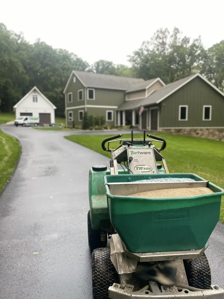 green lawn with spreader equipment in front