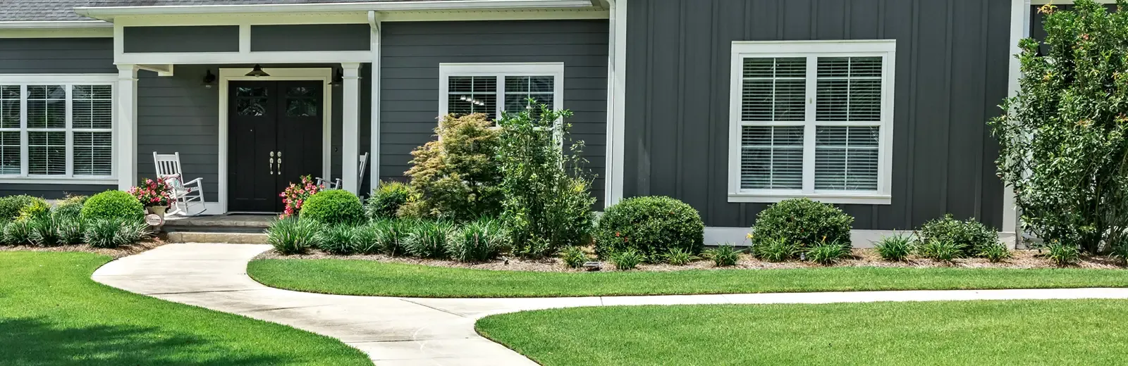 well maintained trees and shrubs in front of nice house