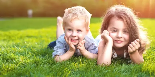 kids laying on thick healthy green grass